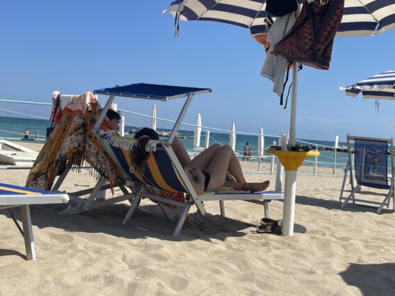 Faro che illumina l’ingresso del porto con onde in controluce